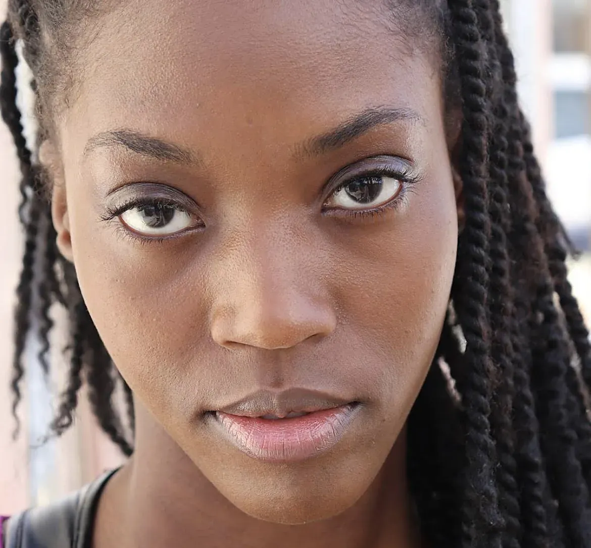 Close-up headshot of an actor with braids